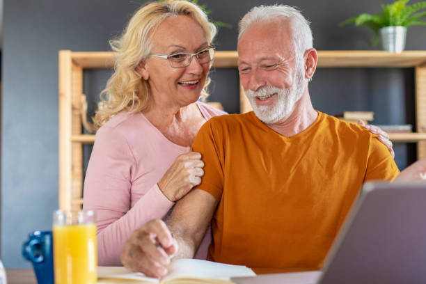 istock Working senior couple at home with laptop 1284127001