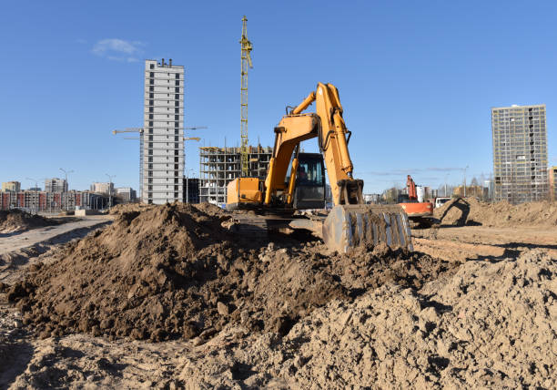istock Excavator on earthworks at construction site. Backhoe on foundation work and road construction 1284127030