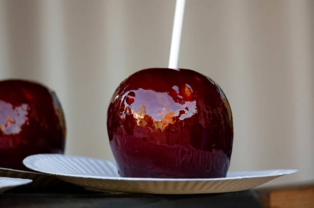 istock Close up of caramelized dark red apples on a stick 1284129160