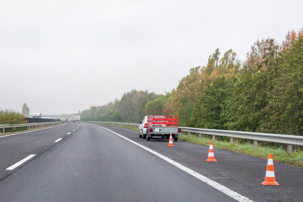 istock Faulty car with red trailer and traffic cones on emergency stopping lane on roadside. Problem with vehicle on highway 1284129471