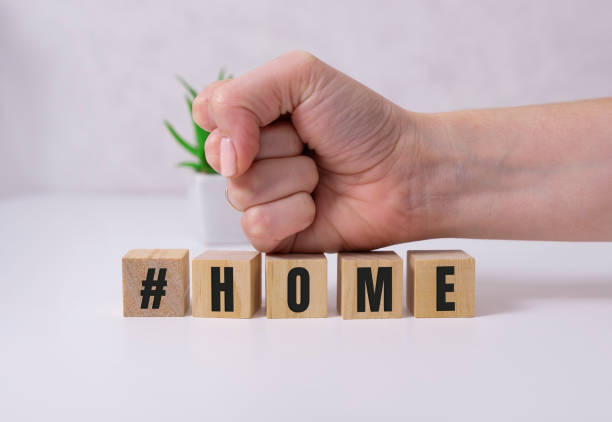 istock Coronavirus home lightbox sign with hashtag message HOME. COVID-19 text to promote self isolation staying at home. 1284132723
