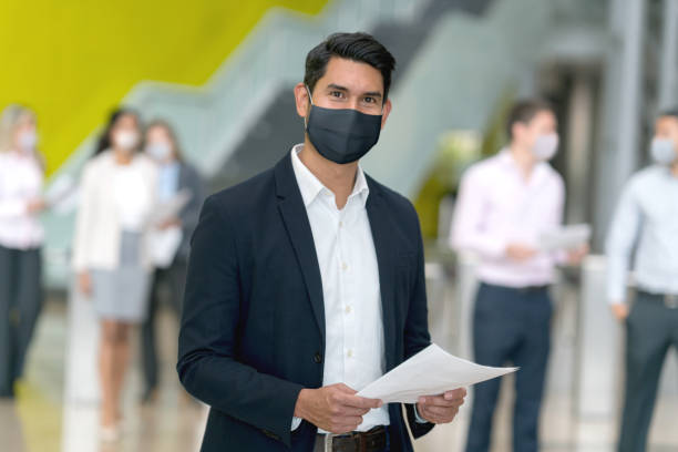 istock Business man wearing a facemask while working at the office 1284133345