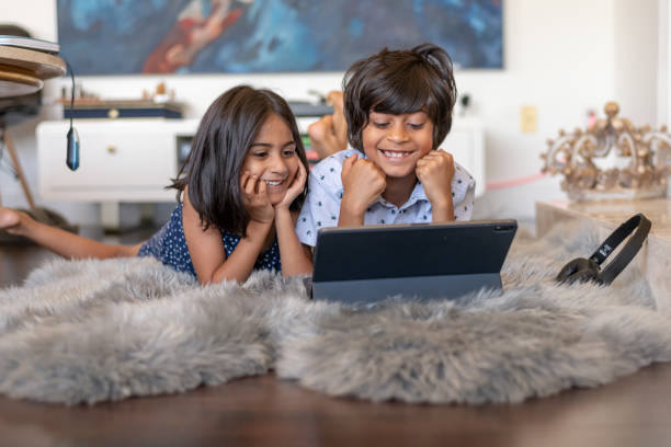 istock Brother and sister watching video on tablet computer 1284133770