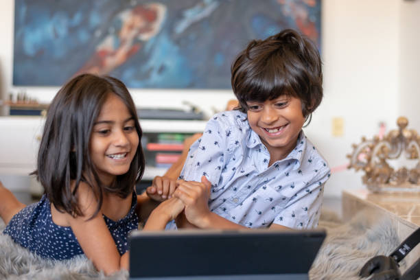 istock Happy brother and sister playing game and doing screen time on tablet computer 1284133772