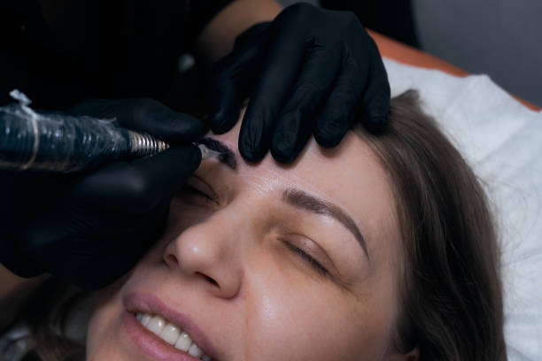 istock Permanent eyebrow makeup procedure. Eyebrow tattooing, process. The use of tools by a master for permanent eyebrow makeup. 1284133908