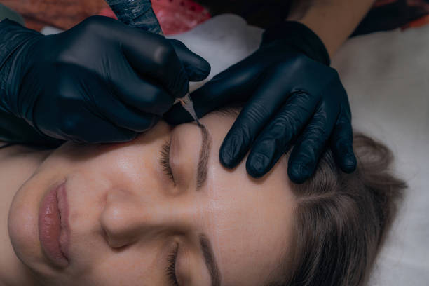 istock Permanent eyebrow makeup procedure. Eyebrow tattooing, process. The use of tools by a master for permanent eyebrow makeup. 1284133912