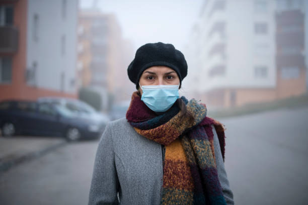 istock Woman with protective face mask in pollution city. 1284133972