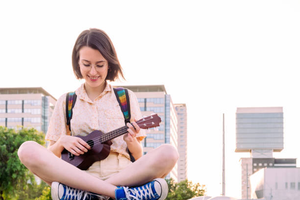 piękna młoda kobieta w trampkach grających ukulele - 20s acoustic guitar adult art zdjęcia i obrazy z banku zdjęć