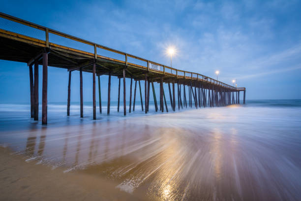 onde nell'oceano atlantico e il molo di pesca al crepuscolo, a ocean city, maryland - maryland fishing atlantic ocean sea foto e immagini stock