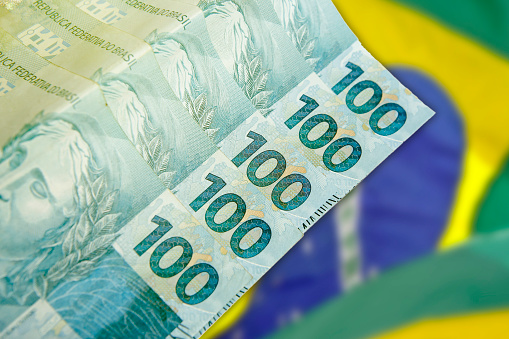 Manos sosteniendo billetes reales brasileños - Dinero de Brasil - Notas de Real - Brasil BRL billete photo