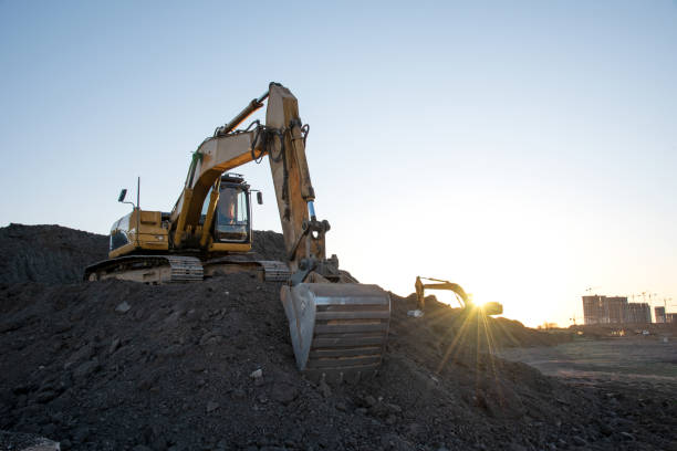 istock Excavator on earthworks at construction site on sunset background. 1284136322