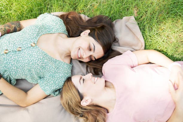 istock Cute lesbian women face to face resting on the grass 1284137785
