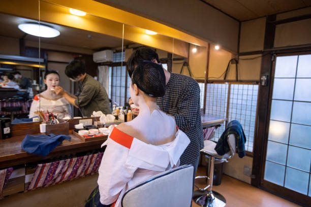 istock Make-up artist applying red lip to young female client for Maiko makeover experience 1284137905