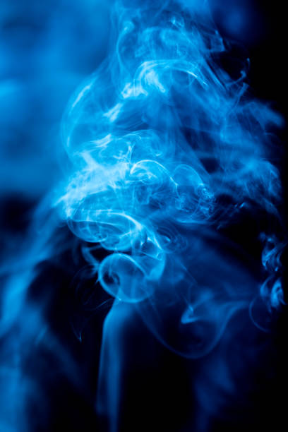 istock Blue abstract shaped smoke against black background. Abstract background 1284138846
