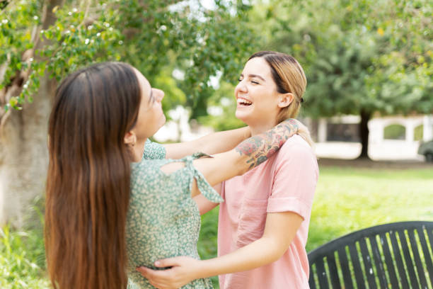 istock Girlfriends embracing and laughing in the park 1284139561