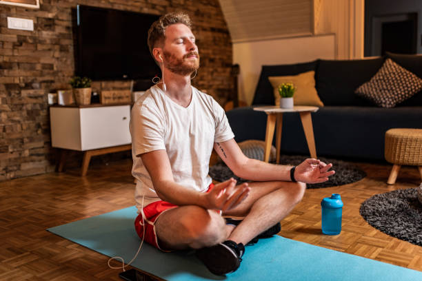 istock Young sportsman meditating at home. 1284139679