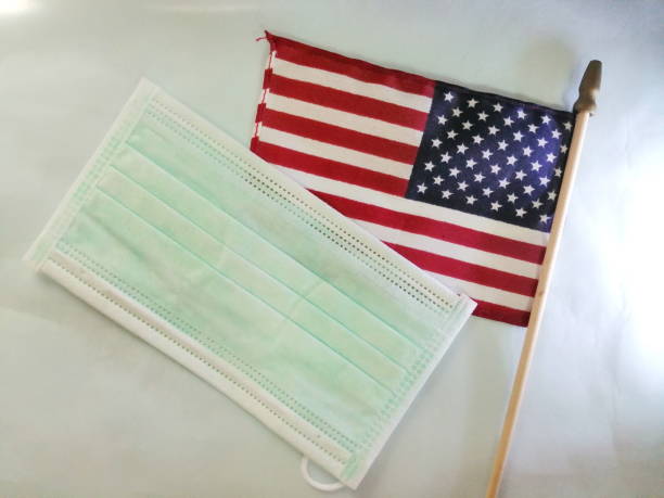 istock American flag and face mask on white desk 1284144520