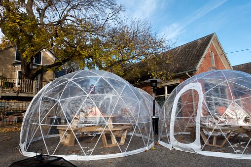 A plastic igloo styled hutch used during the COVID-19 pandemic at a restaurant for physical distancing