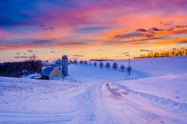 Sunset over a snow covered road and a farm in a rural area of York County, Pennsylvania