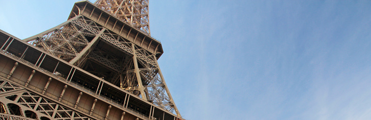 Eiffel tower on a wide banner with blue sky, place for text.