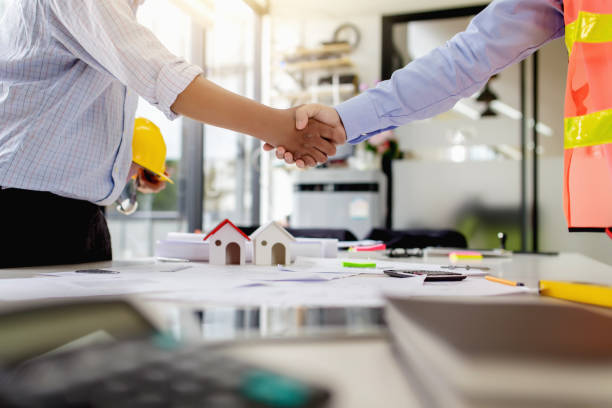 istock Investor and engineer shaking hands at meeting. 1284153056
