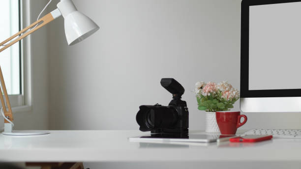 istock Computer desk with camera, smartphone, flower vase and copy space, clipping path 1284155963