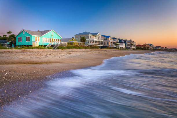 Waves in the Atlantic Ocean and beachfront homes at sunrise, Edisto Beach, South Carolina Waves in the Atlantic Ocean and beachfront homes at sunrise, Edisto Beach, South Carolina edisto island south carolina stock pictures, royalty-free photos & images