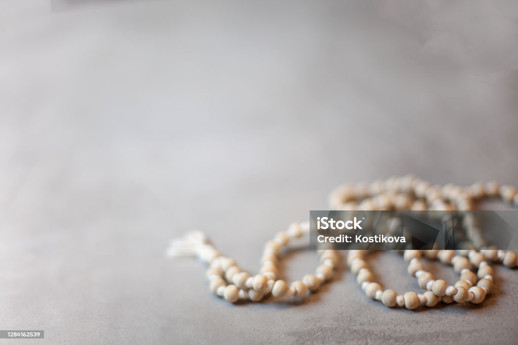 Top view white rosary beads isolated on the grey background Top view prayer rosary beads on the grey background with copy space. Praying and reciting beads. Tibetan Buddhist rosary, called mala or japamala. Mala Island Stock Photo