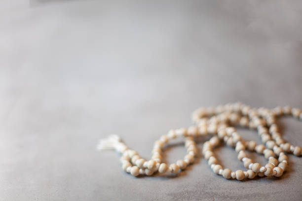 Top view white rosary beads isolated on the grey background Top view prayer rosary beads on the grey background with copy space. Praying and reciting beads. Tibetan Buddhist rosary, called mala or japamala. mantra stock pictures, royalty-free photos & images