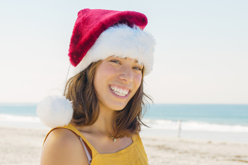 Woman at the beach in a Santa Hat