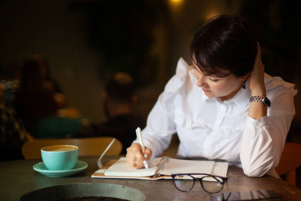 istock Young woman in business white blouse writing notes 1284164419