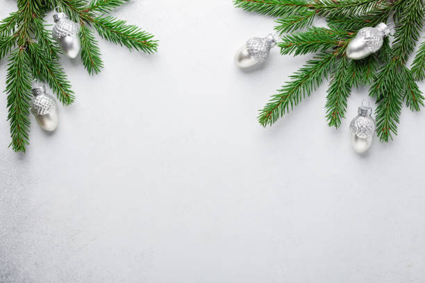 istock Christmas composition. Fir tree branches with silver decorative oaks on stone background 1284164509