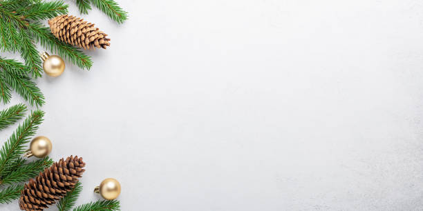 istock Minimal christmas composition. Fir tree branches with golden christmas balls and cone on stone background 1284164554
