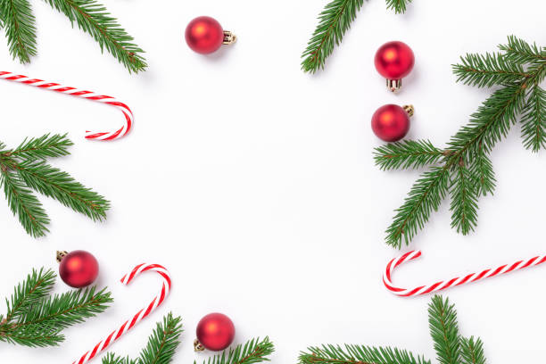 istock Christmas composition with fir tree branches, red christmas balls and candy cane on white background. Top view. Copy space 1284164754