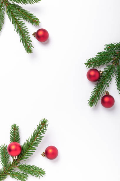istock Minimal christmas composition. Fir tree branches with golden christmas balls on white background. Vertical 1284164766