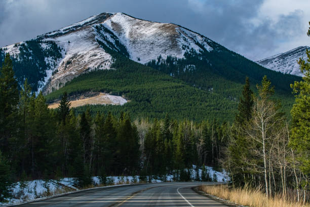 istock Kananaskis, Alberta - Single Lane Highway with Mount Allan in the Background 1284165776