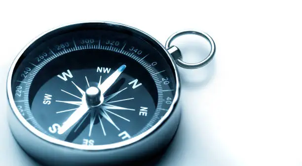Classic magnetic compass, metal navigational compass on a white background.
