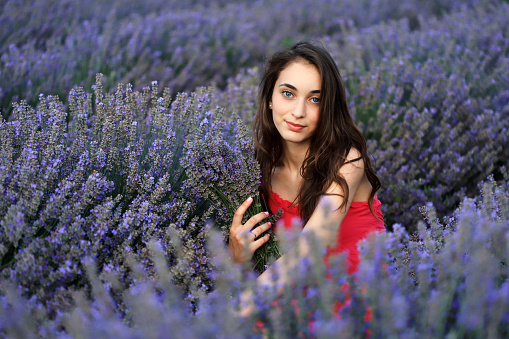 Happy young girl holding bouquet in lavender field