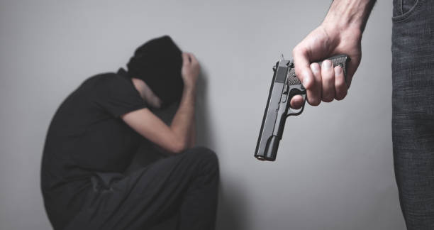 istock Person with a handgun with a his victim. 1284169863