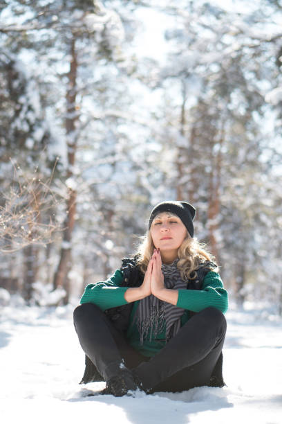 istock Woman sits and prays in winter forest. 1284172721