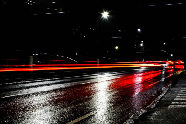 lights of cars at night. street lights. night city. long-exposure photograph night road. wet road after rain - damp course imagens e fotografias de stock