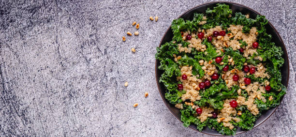 salade saine de chou frisé et de quinoa cru avec la canneberge et la noix de pin - 9780 photos et images de collection