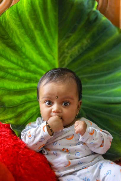 istock Cute Indian little child playing on bed with green leaf background 1284179474