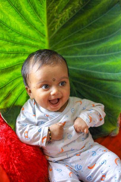 istock Cute Indian little child playing on bed with green leaf background 1284179537