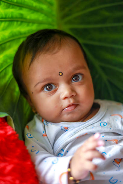istock Cute Indian little child playing on bed with green leaf background 1284179696