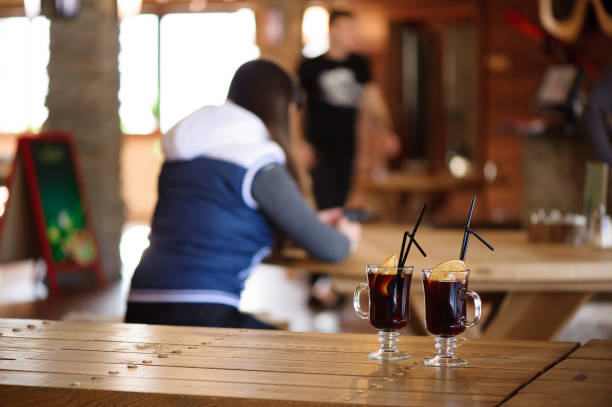 dos copas con vino caliente y sabroso sobre una mesa de madera en un café - beer ski apres ski snow fotografías e imágenes de stock
