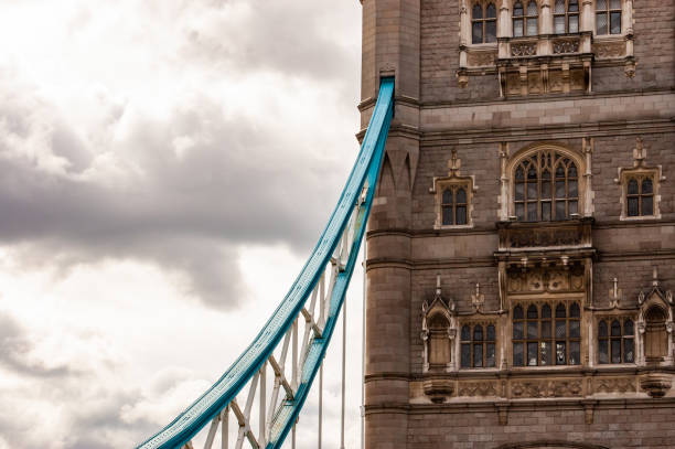 el vibrante fragmento de metal azul del famoso tower bridge de londres colgado de una de las dos torres principales del puente - recubrimiento capa exterior fotografías e imágenes de stock