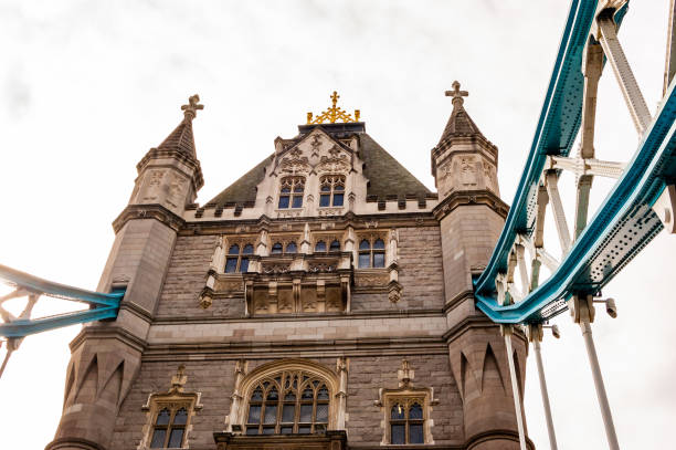 el vibrante fragmento de metal azul del famoso tower bridge de londres colgado de una de las dos torres principales del puente - recubrimiento capa exterior fotografías e imágenes de stock