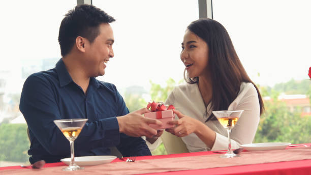 istock Romantic couple giving gift to lover at restaurant 1284182029