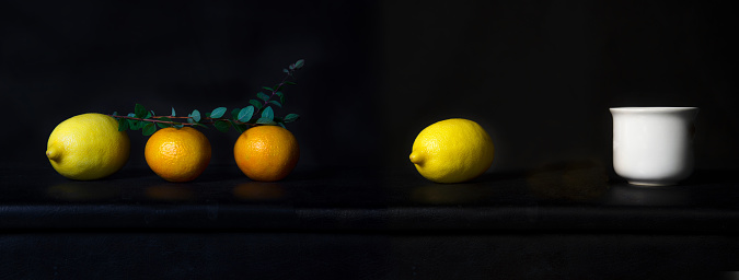 orange and lemon fruit for food with white ceramic drink cup classic still life on black leather background